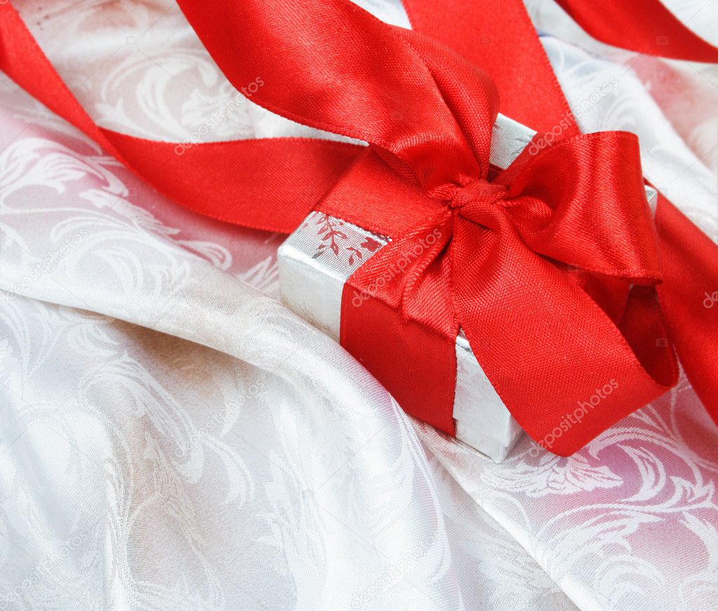Gift Box with Red Ribbon over Silk