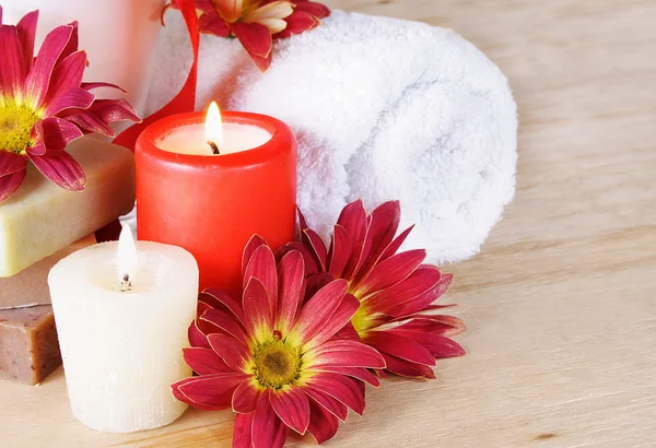 Toiletartikelen met een handdoek, kaarsen en bloemen — Stockfoto