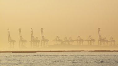 Container cranes on a foggy morning clipart