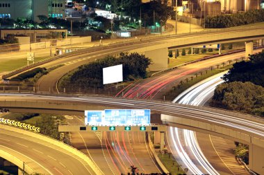 Freeway in night with cars light in modern city. clipart