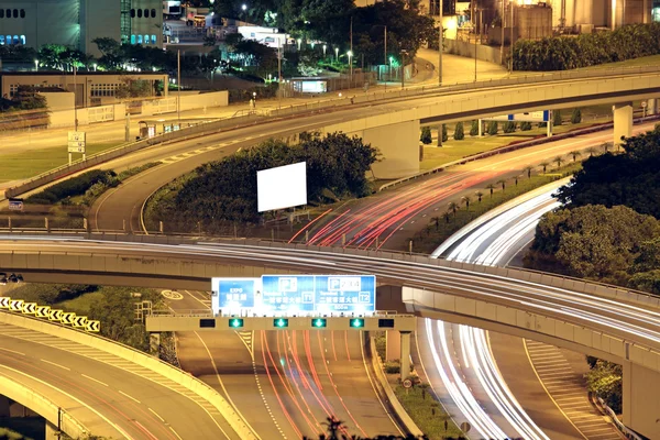 Autobahn in der Nacht mit beleuchteten Autos in der modernen Stadt. — Stockfoto