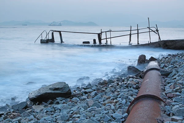 Tubo de metal viejo y camino al mar — Foto de Stock