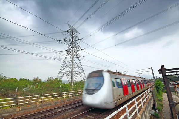 Velocidade de trem sob a torre de energia — Fotografia de Stock