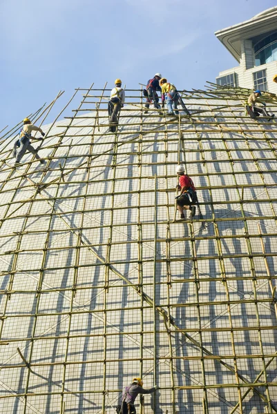 Closeup of construction worker assembling scaffold on building s — Stock Photo, Image