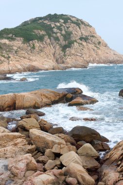 Kayalık deniz kıyısı ve bulanık su Shek o, Hong Kong 'da