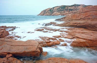 Kayalık deniz kıyısı ve bulanık su Shek o, Hong Kong 'da