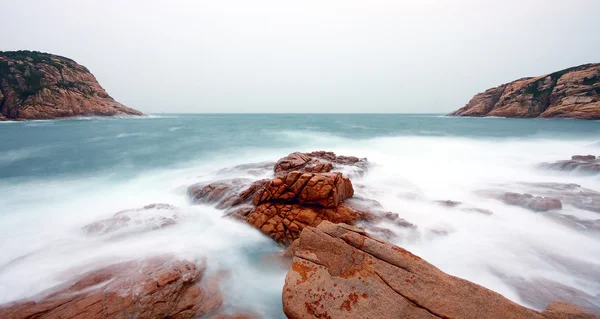 Skaliste wybrzeże morskie i zamazana woda w shek o, hong kong — Zdjęcie stockowe