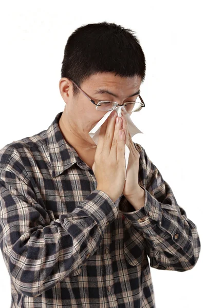 Stock image Young man with a cold blowing nose on tissue