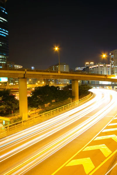 Trafik nattetid med spår av ljus som lämnas av bilarna på en hig — Stockfoto
