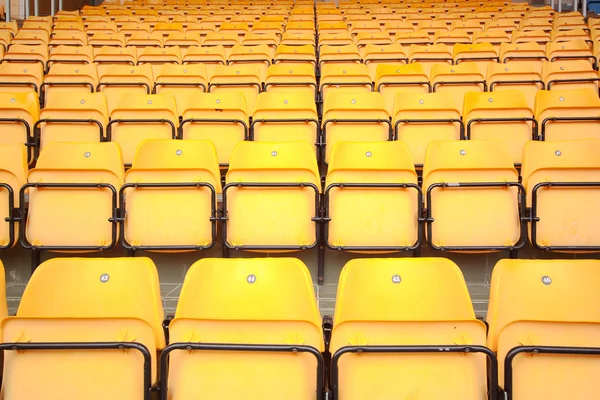 Beaucoup de sièges en plastique jaune au stade — Photo