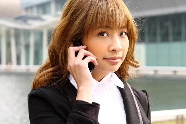 Mooie zakenvrouw op de telefoon op modern gebouw — Stockfoto