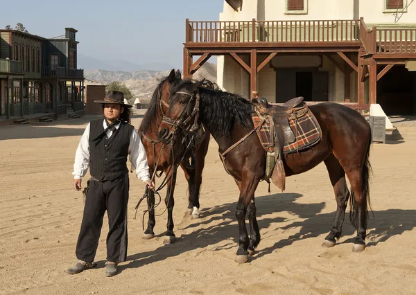 Cowboy Sheriff sosteniendo dos caballos — Foto de Stock