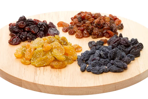 Quatre variétés de raisins secs sur planche à découper — Photo