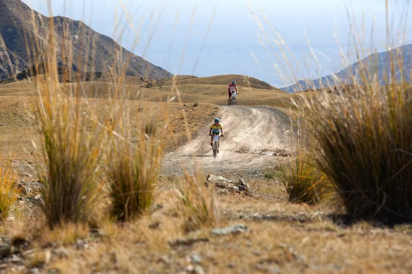 Due ciclisti che pedalano tra le montagne del deserto — Foto Stock