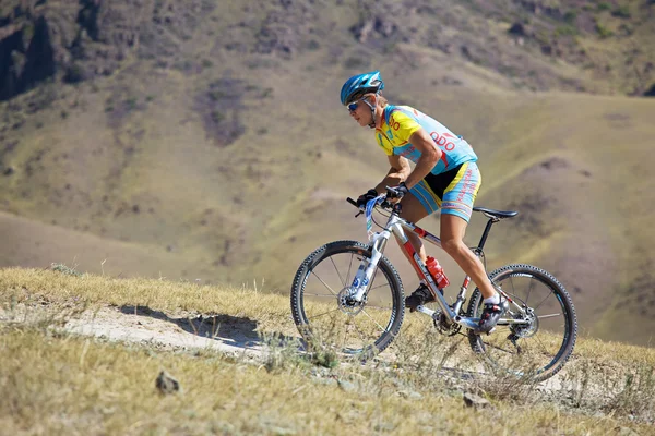 Motociclista montanaro sulla corsa in montagna nel deserto — Foto Stock