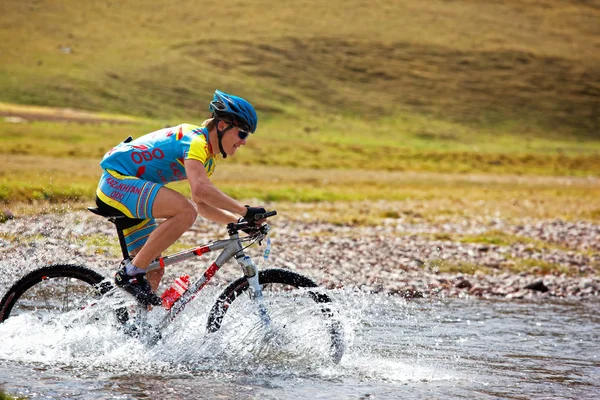 Cyklist i samma hastighet som flyttar berg floden — Stockfoto