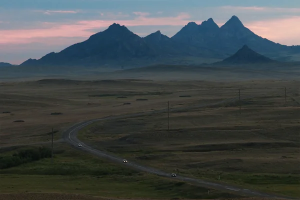 黄昏和路在沙漠山 — 图库照片