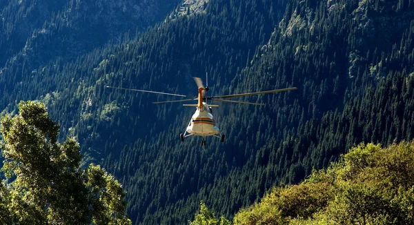 Helicóptero de resgate voa para longe nas montanhas — Fotografia de Stock