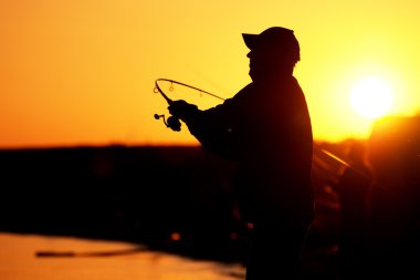 Fisherman at sunset clipart