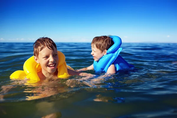 Lachende broers zwemmen — Stockfoto