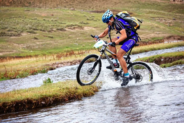 Bisikletçi, hareketli dağ nehir hızında — Stok fotoğraf