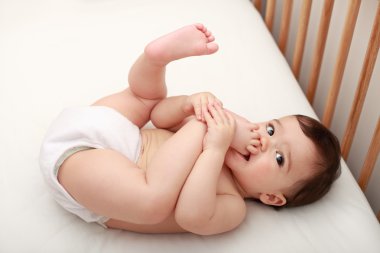 Baby biting his feet clipart