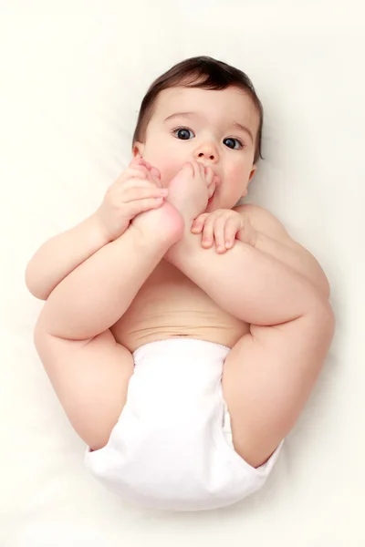 Bebê mordendo seus dedos dos pés — Fotografia de Stock