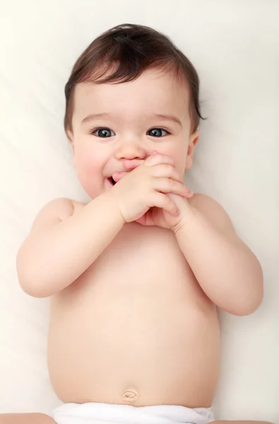 Entzückendes Baby saugt seine Finger Stockfoto