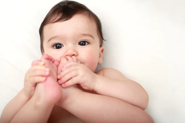 彼の足をしゃぶり赤ちゃん ロイヤリティフリーのストック写真