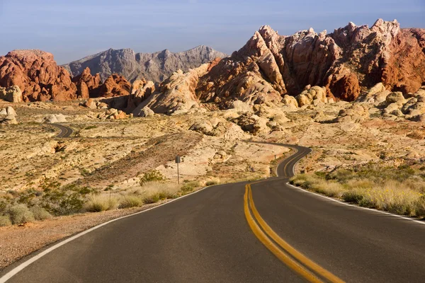 Estrada vazia através de rochas vermelhas — Fotografia de Stock