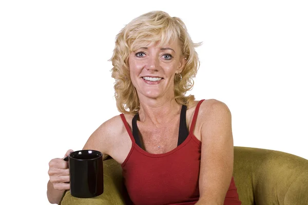 Frau sitzt auf einem Stuhl und trinkt Kaffee — Stockfoto