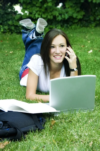 Leuke tiener meisje vaststelling van op het gras bestuderen — Stockfoto