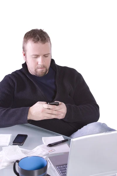 Молодой бизнесмен пишет смс за своим столом — стоковое фото