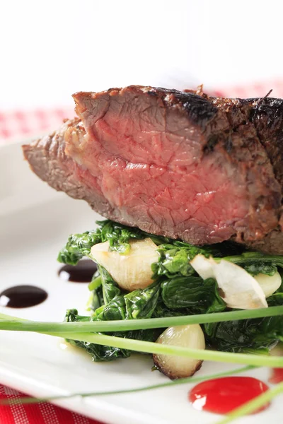 Roast beef and spinach leaves — Stock Photo, Image