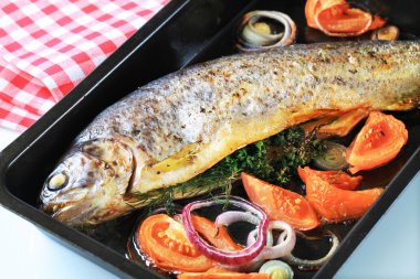 Herb-stuffed trout with tomatoes clipart