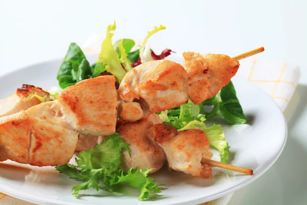 Chicken skewers and salad greens — Stock Photo, Image