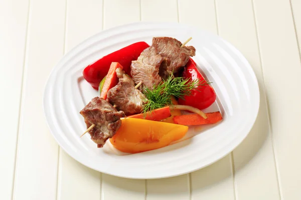 Pečené maso na jehle a pečená zelenina — Stock fotografie