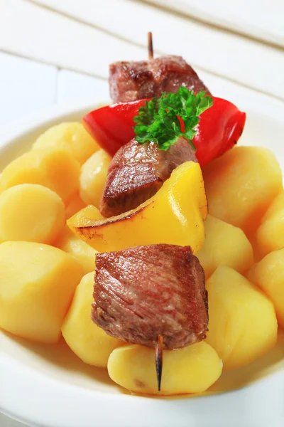 Espetos de carne grelhada e batatas — Fotografia de Stock