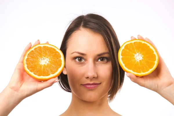 Mladá žena držící dvě poloviny pomeranče — Stock fotografie