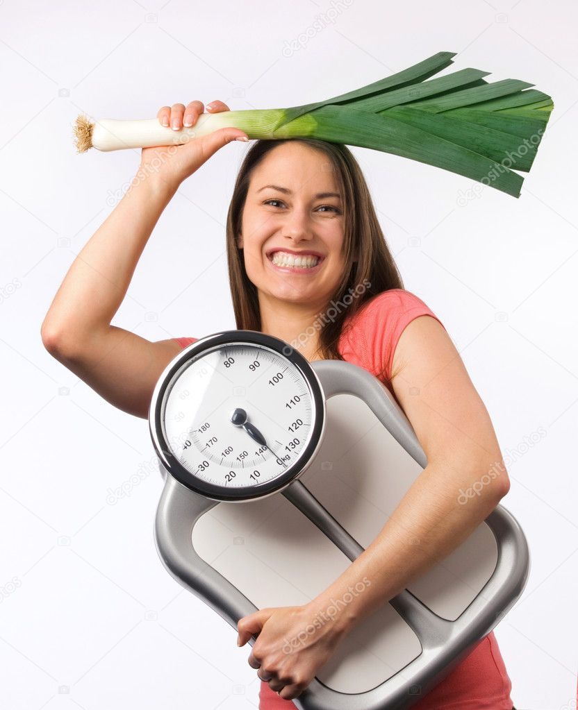 Young woman holding a scale and fresh vegetable