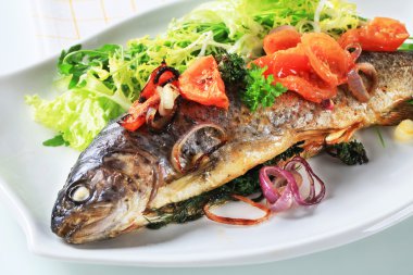 Baked trout with tomatoes and green salad clipart