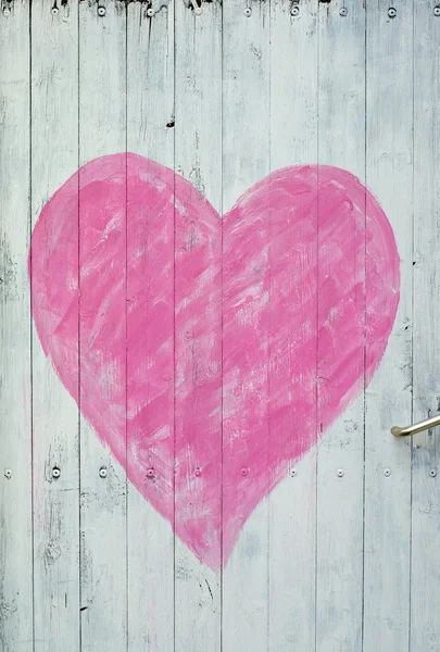 Porta de madeira com coração rosa — Fotografia de Stock