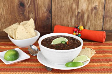 Black bean mexican soup with chips and lime. clipart