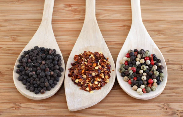 stock image Three types of pepper on wooden spoons