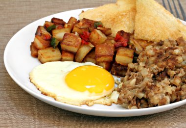 Fried egg, home fries and hash breakfast. clipart