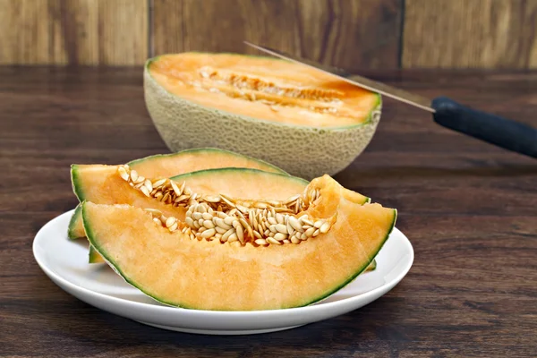 Sliced cantaloupe on a plate with seeds. — Stock Photo, Image