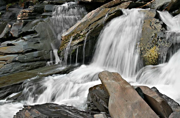Verschleierter Wasserfall in felsigen Schluchten in den Bergen. — Stockfoto