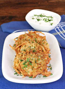 Potato Latkes and sour cream, vertical. clipart