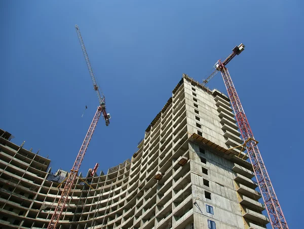 Building crane at the background of a multi-storey building — Stock Photo, Image
