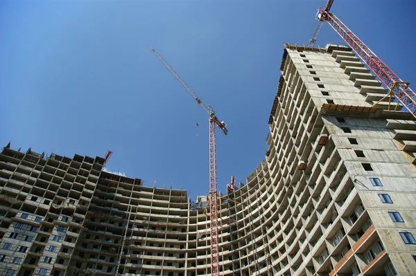 Building crane at the background of a multi-storey building — Stock Photo, Image